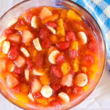 fruit salad with peach pie filling in a glass bowl on table