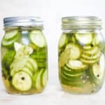 two pickled cucumbers in mason jars
