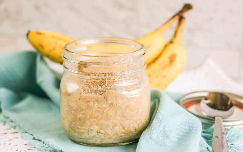 peanut butter overnight oats in a jar with bananas on table