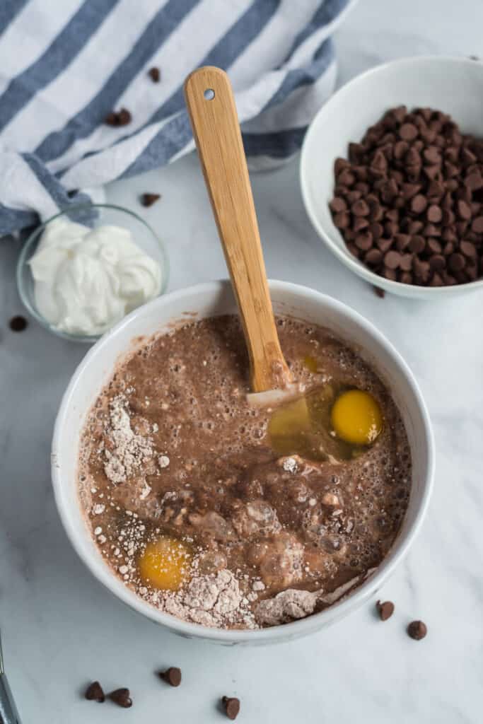 chocolate chip cake batter with eggs and wooden spatula