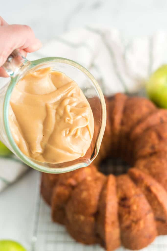 putting caramel icing and frosting on the apple bundt cake