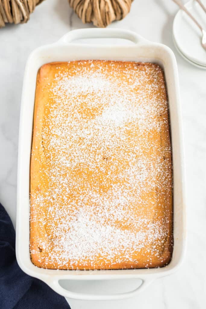 pumpkin pie cake in a white dish with sugar on top