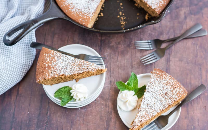 syrup cake with powdered sugar on top made in cast iron skillet