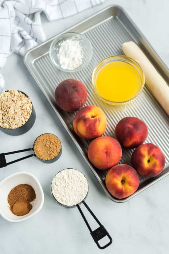 ingredients for peach slab pie on a jelly roll pan