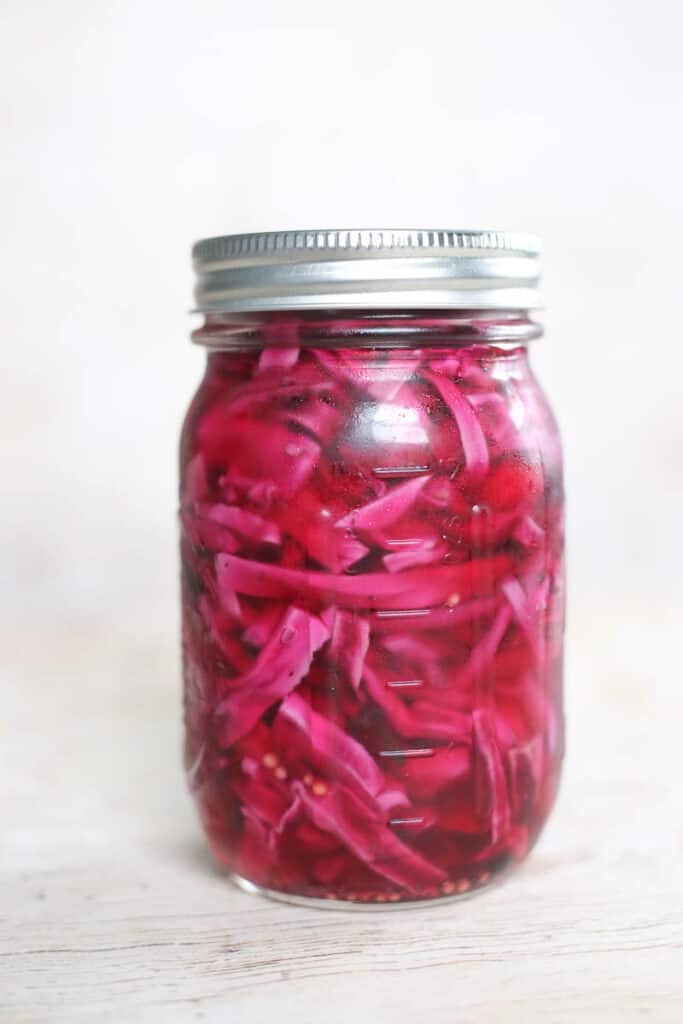 shredded cabbage in a jar with spices ready to be refrigerated