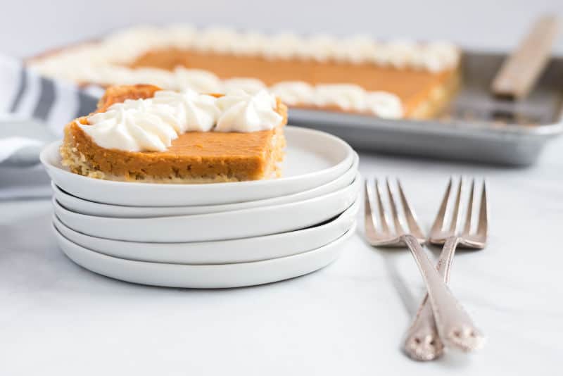 sweet potato slab pie with whip cream on white plates on table