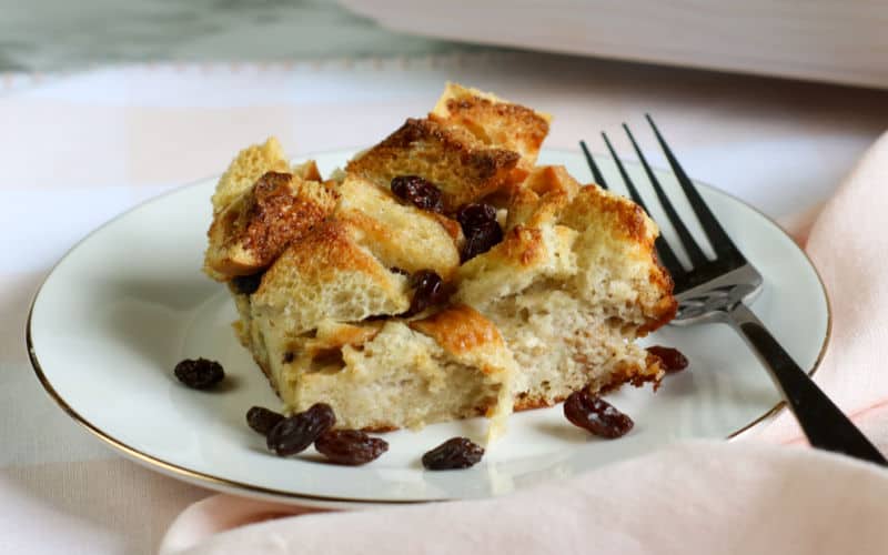 piece of bread pudding on plate with raisins